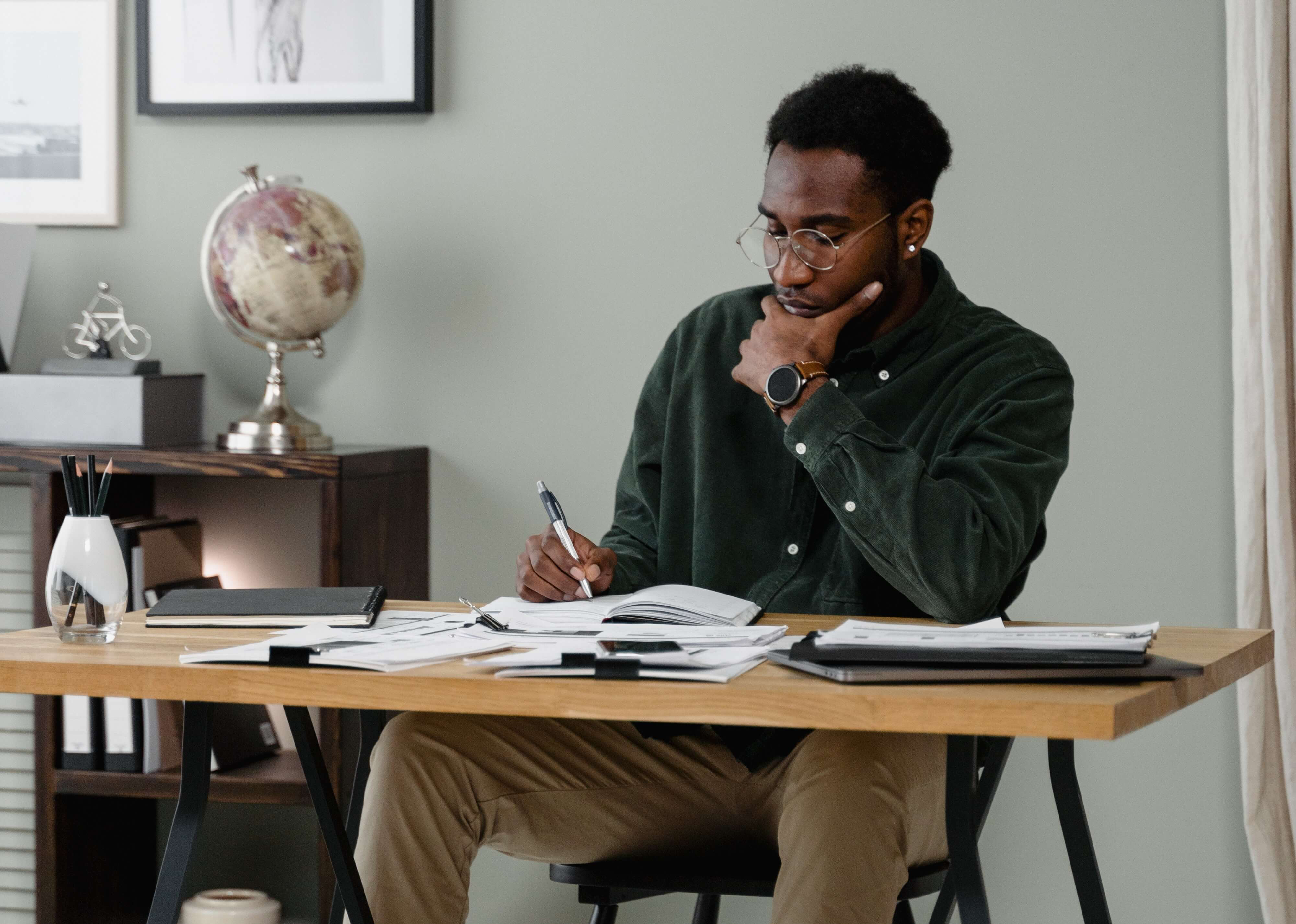 somber man writing at desk